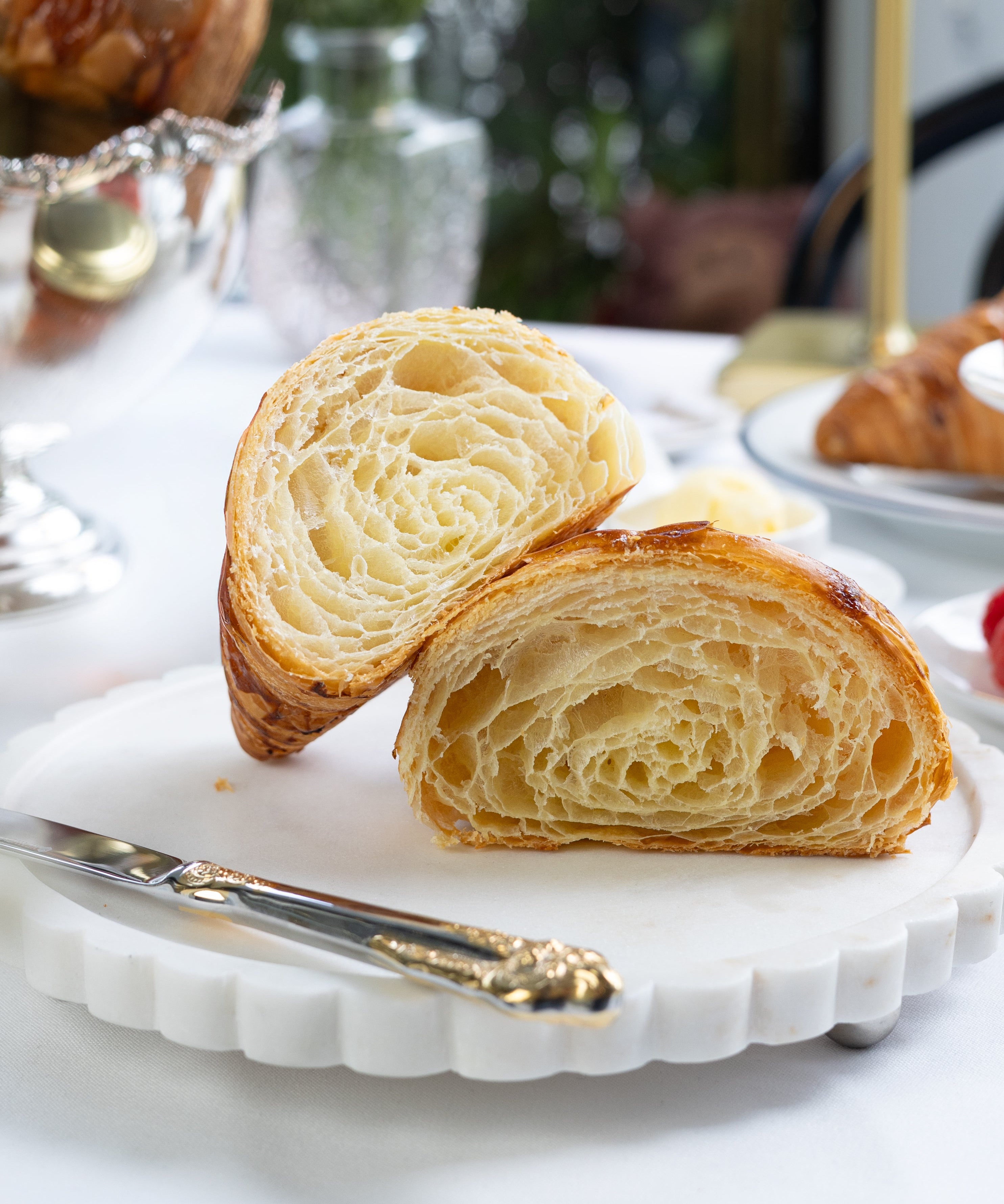 Sliced croissant on a decorative plate with a blurred background