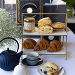 Tea set with pastries and a decorative box on a white table.