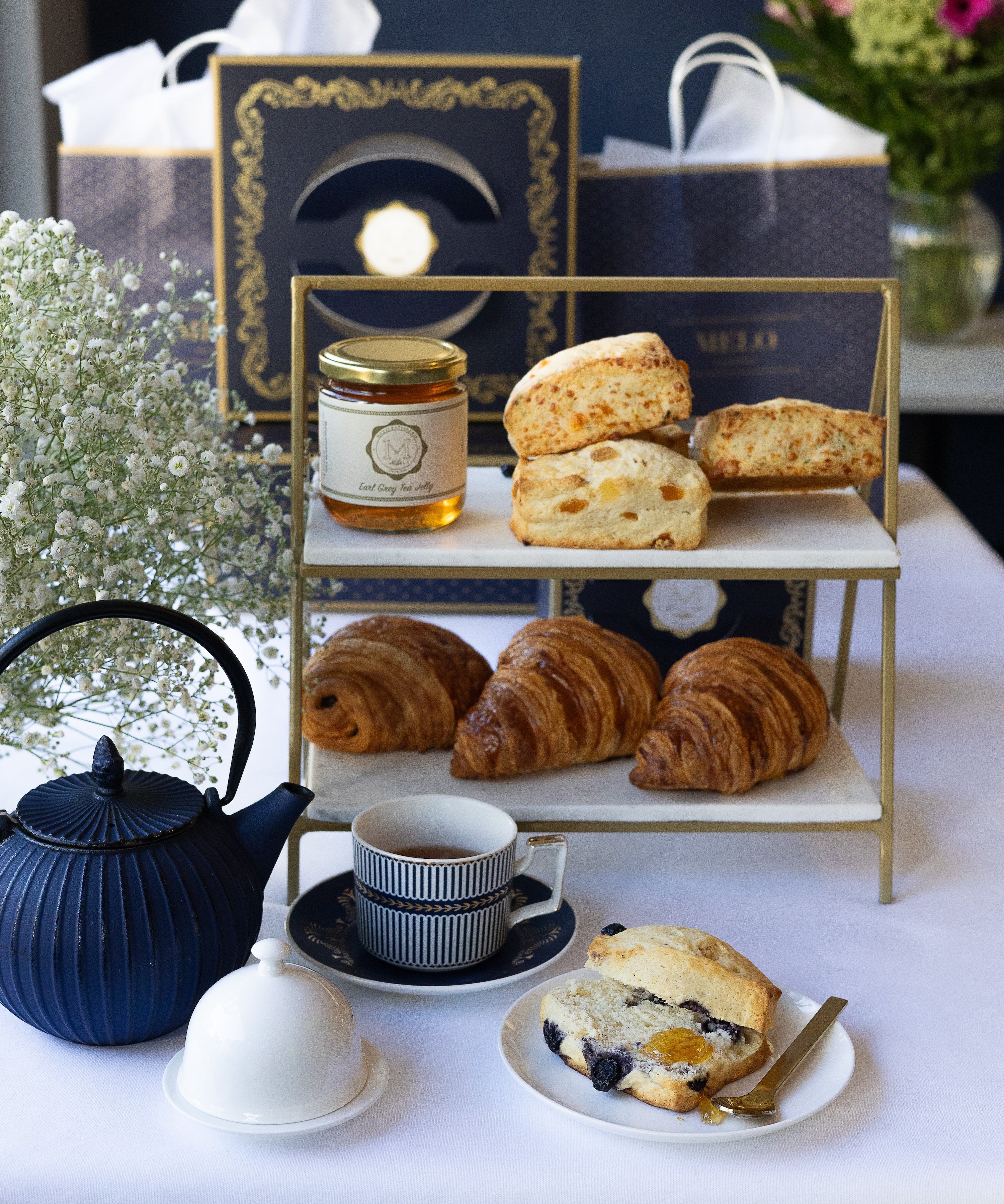 Tea set with pastries and a decorative box on a white table.