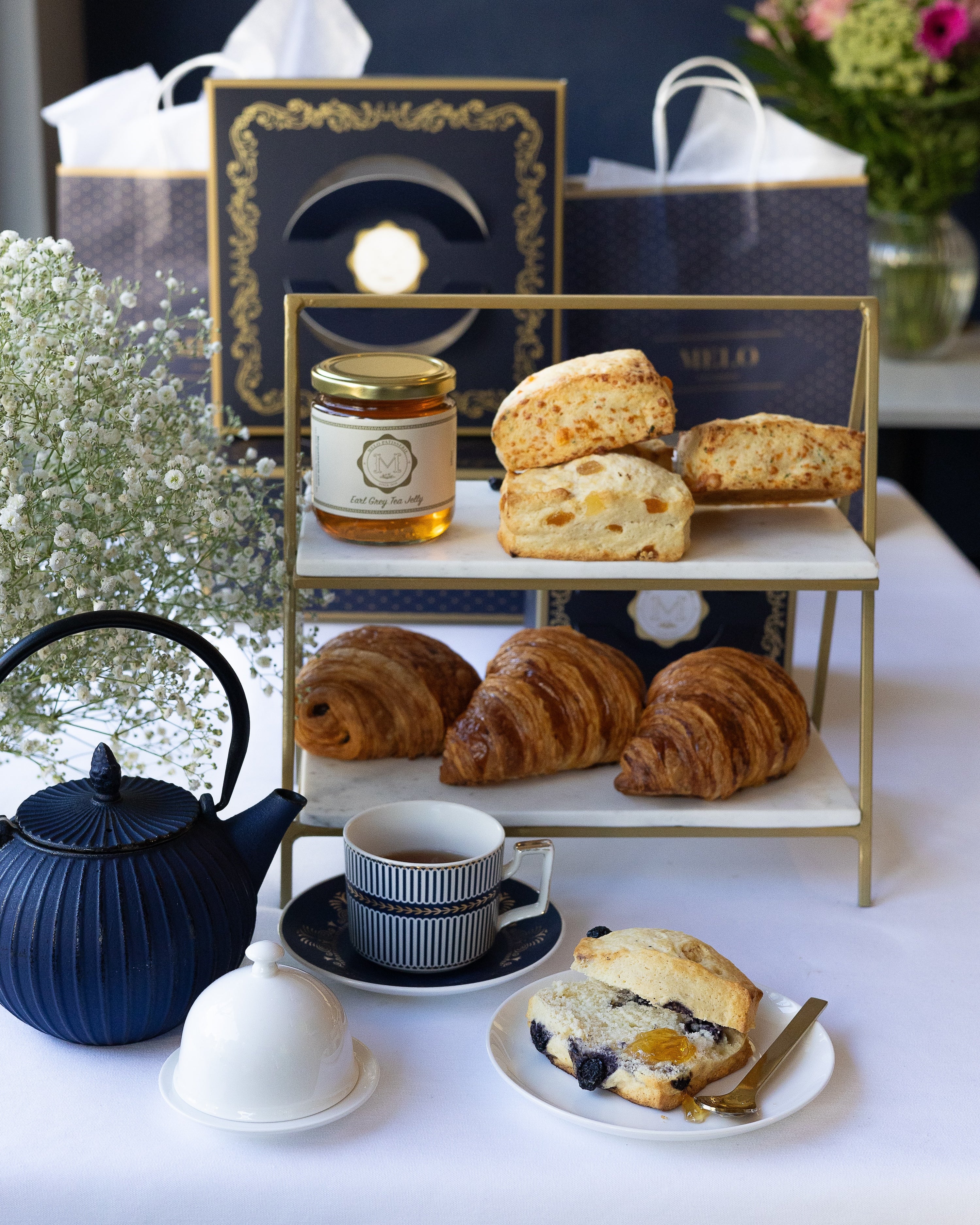Tea set with pastries and a decorative box on a white table.