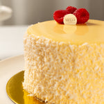 Yellow cake with raspberry decorations on a gold plate