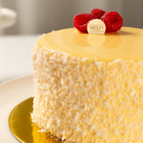Yellow cake with raspberry decorations on a gold plate