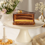 Chocolate mousse cake on a white cake stand with decorative elements