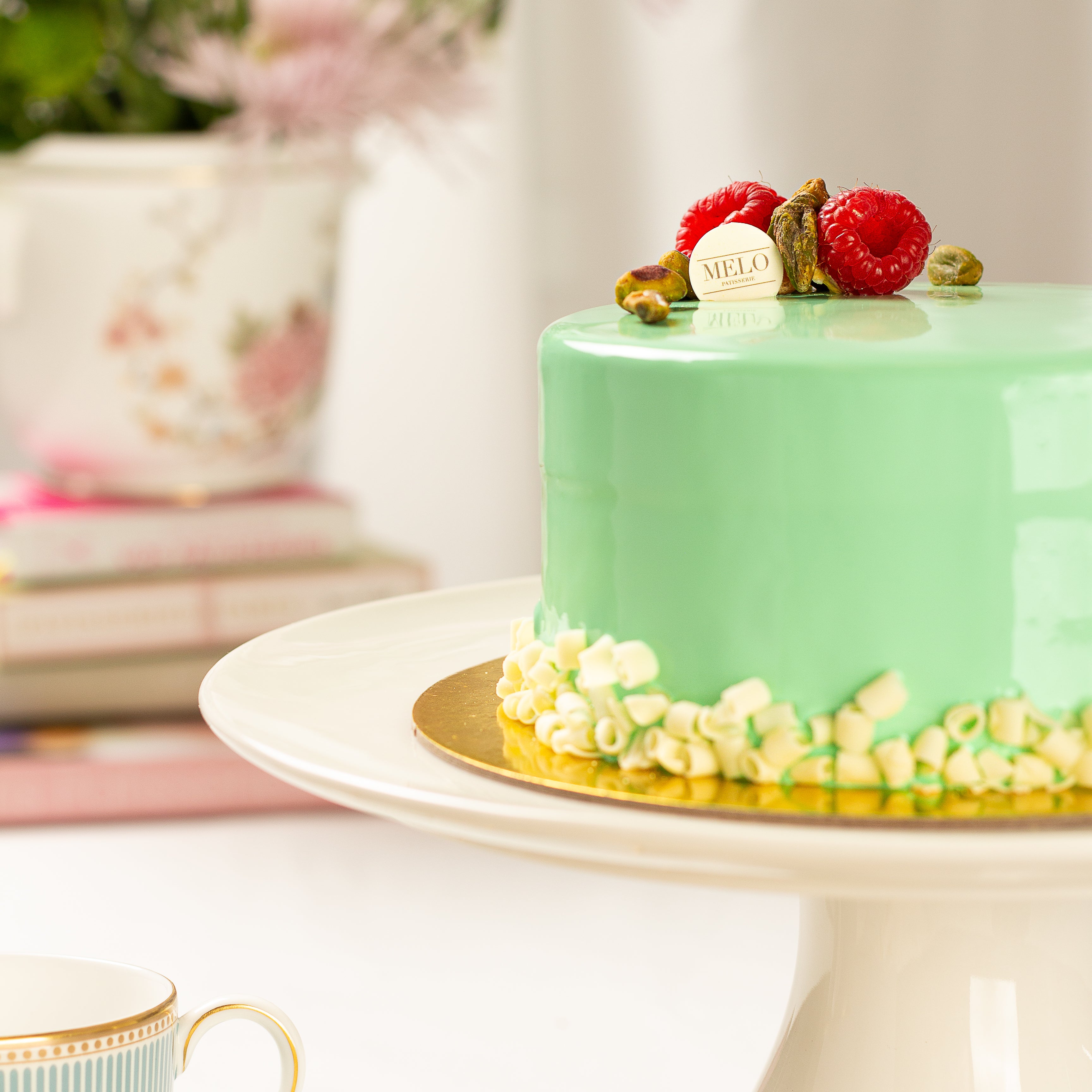 Green cake with raspberries on a white plate with a blurred background