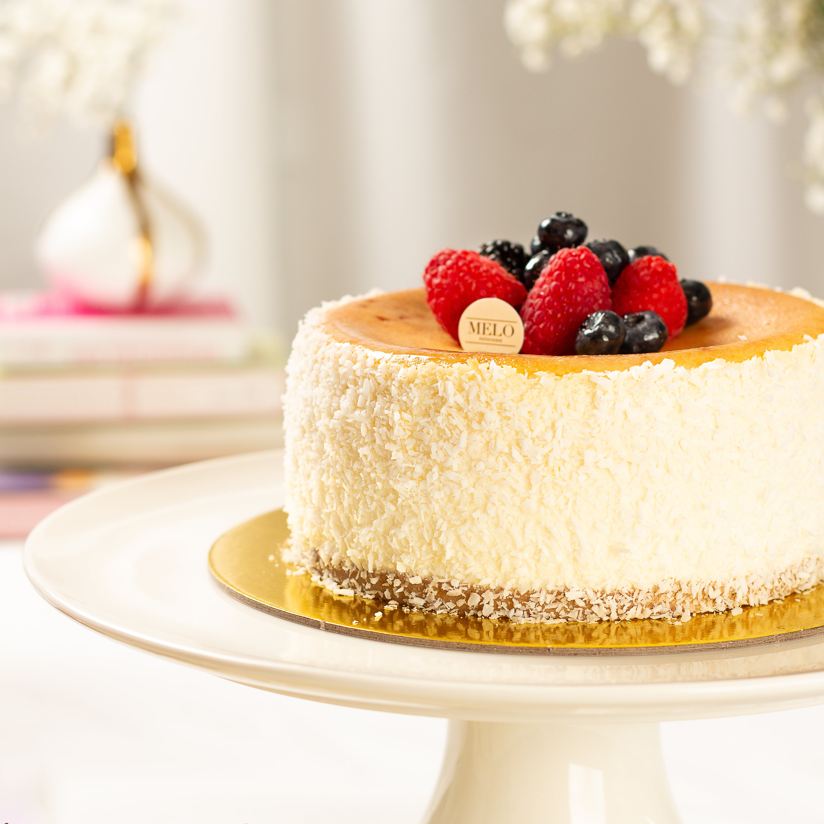 Cheesecake with berries on a white plate with a blurred background