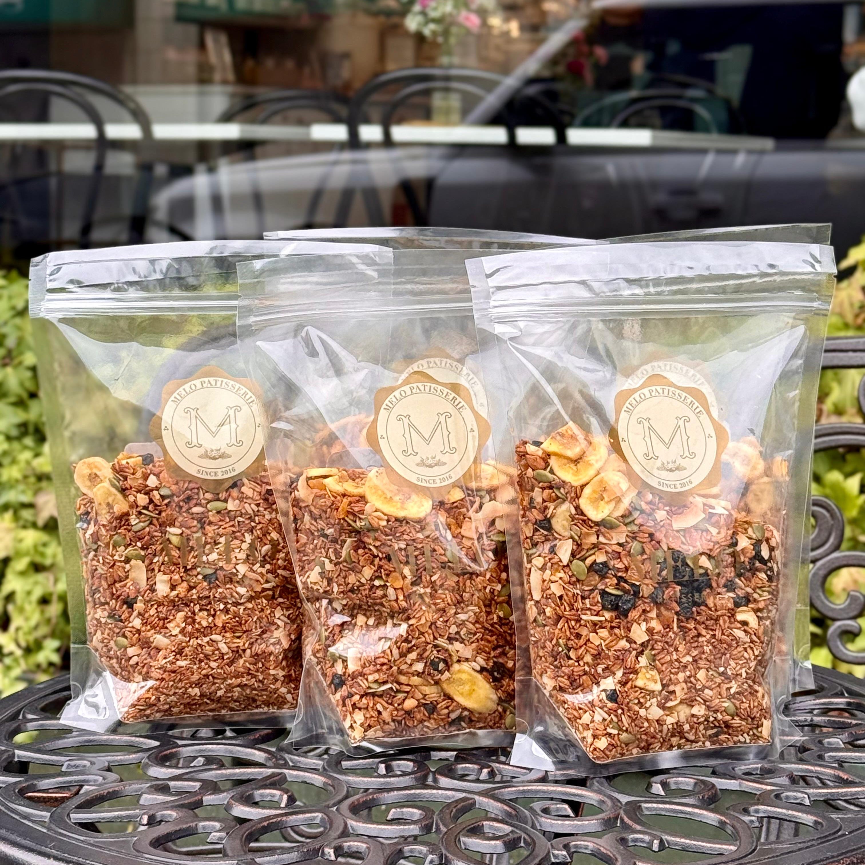 Three packages of birdseed on a table outdoors with a blurred background