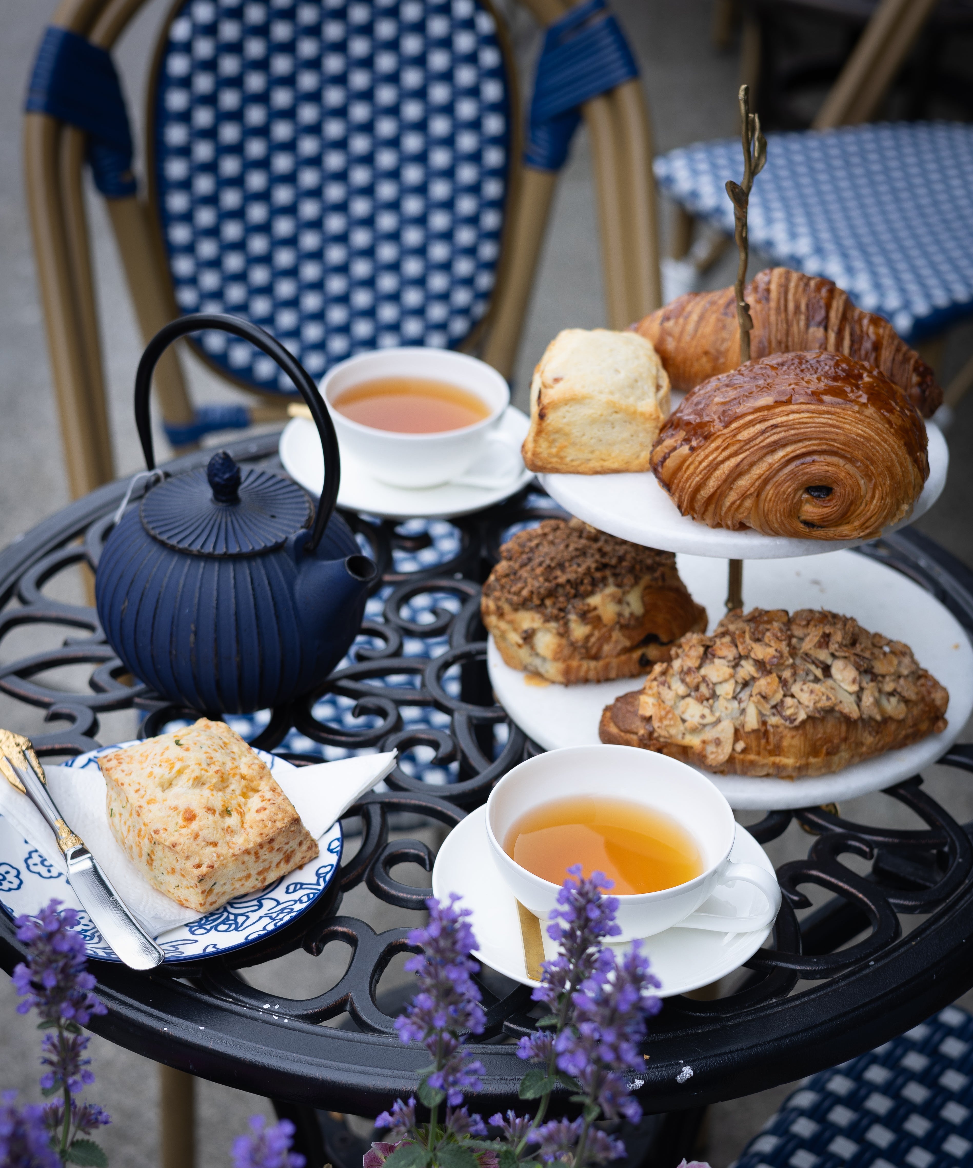 Tea set with scones and pastries on a table outdoors