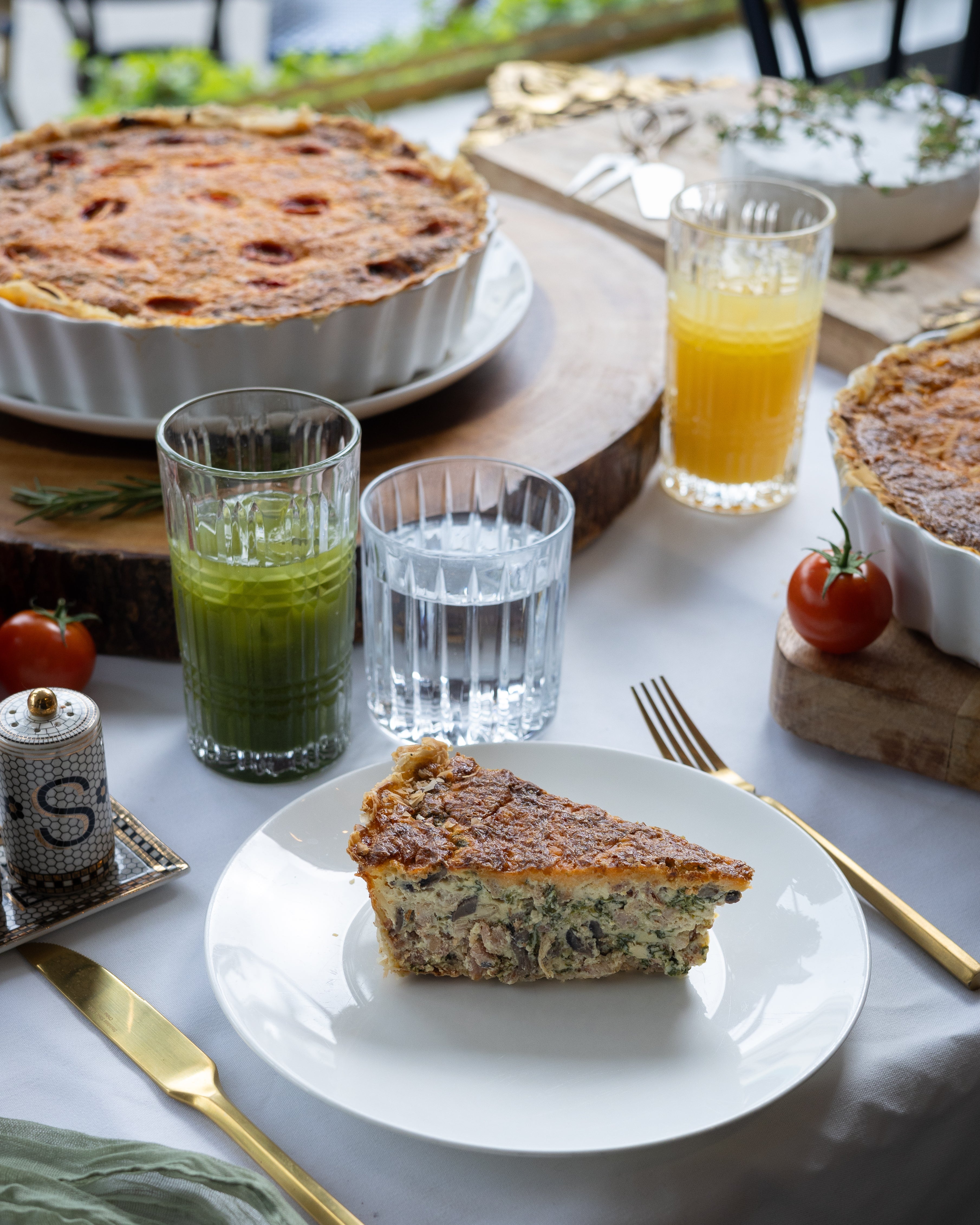 Slice of pie on a plate with drinks and utensils on a table