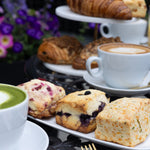 Assorted pastries and a cup of coffee on a table with a blurred background