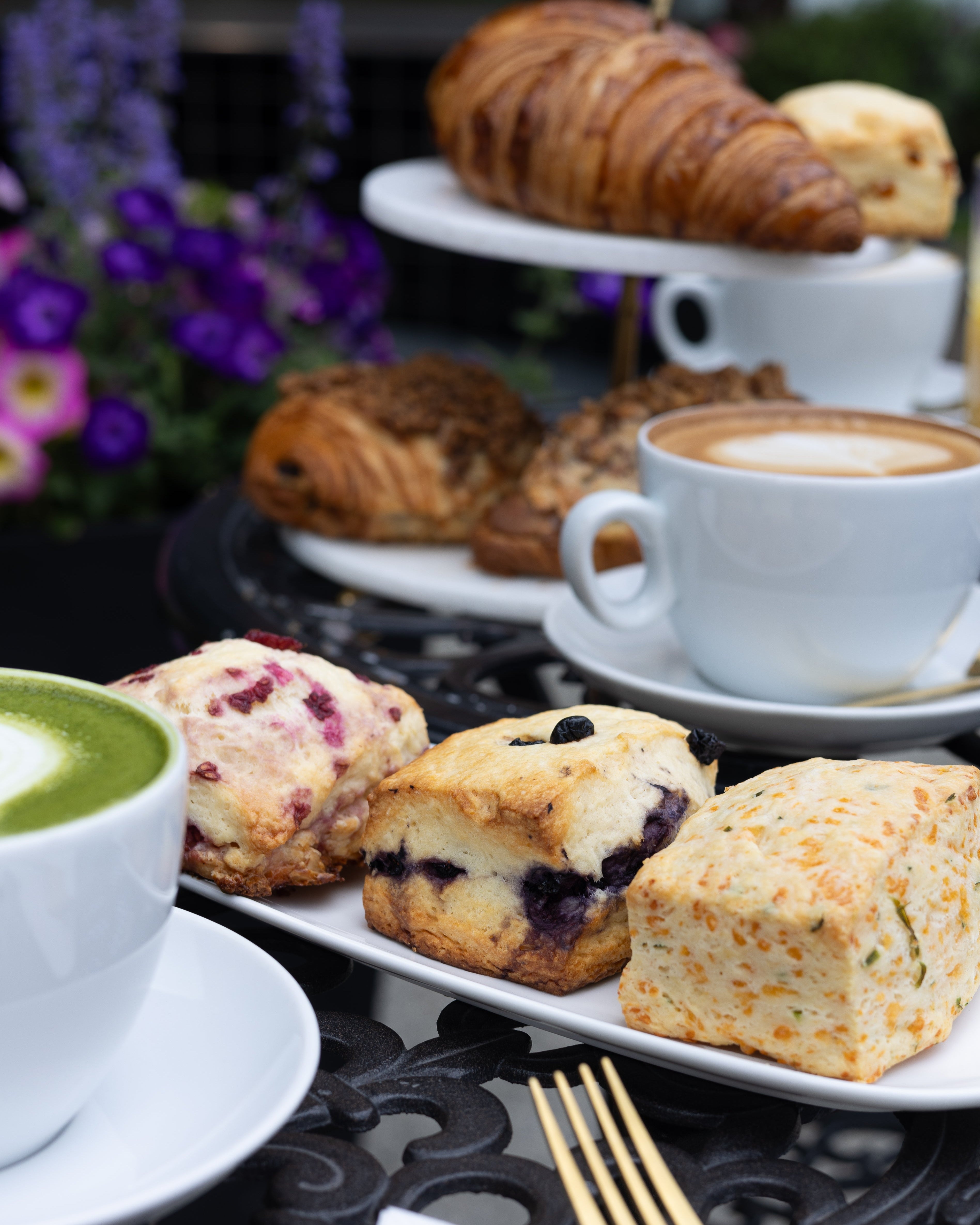 Assorted pastries and a cup of coffee on a table with a blurred background