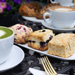 Assorted pastries and a cup of coffee on a table with a blurred background