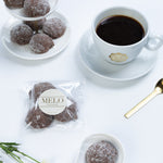 Almond earl grey cookies with a cup of coffee on a white surface, featuring the brand 'Melo'.