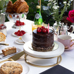 Table setting with a chocolate cake, cookies, and a Chanel menu in an outdoor setting.