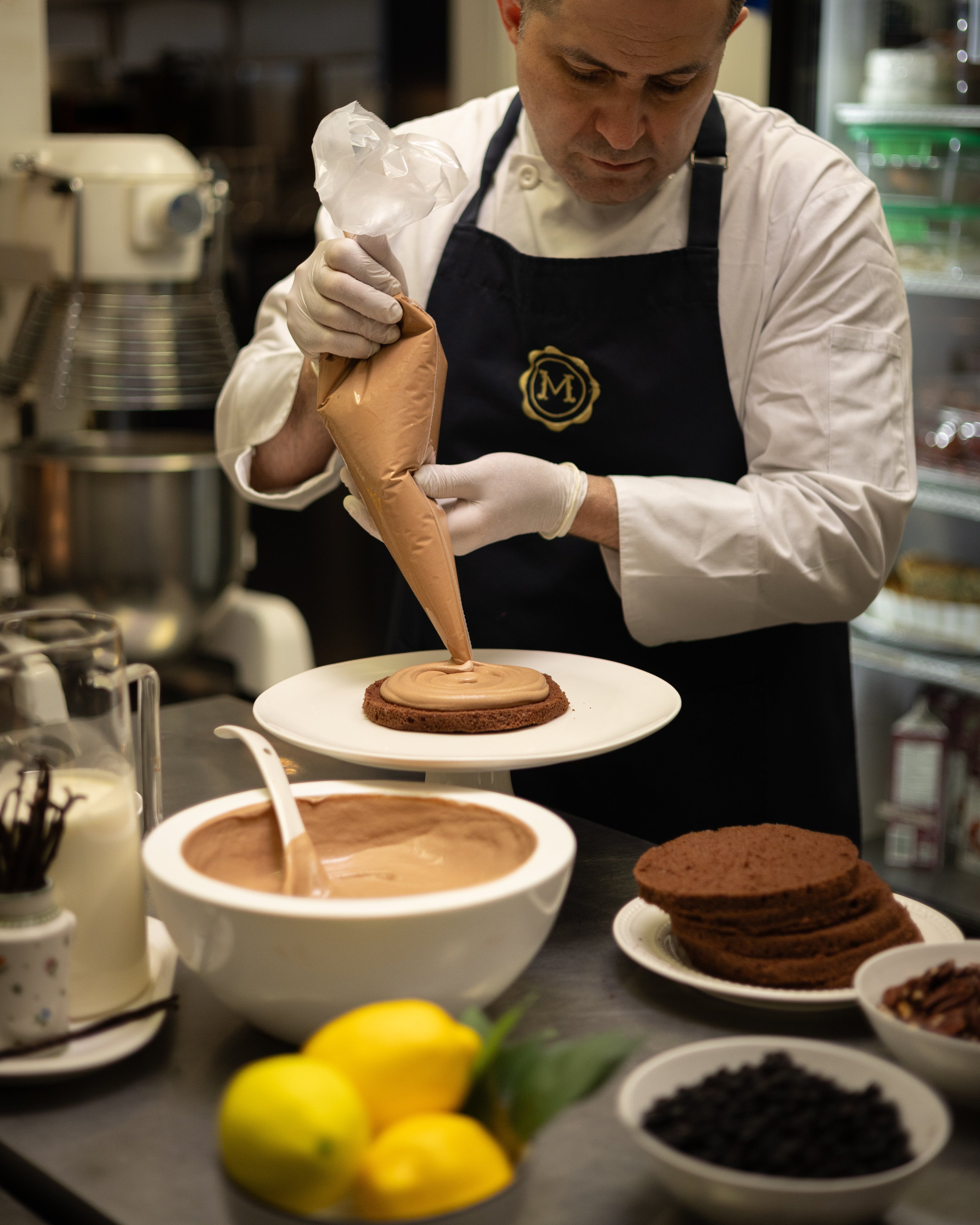 Chef in a kitchen preparing a dessert with chocolate icing